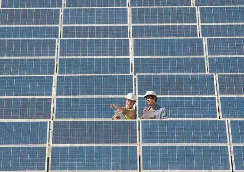 Técnicos revisando un campo de paneles solares