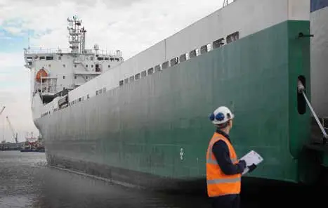 Inspector junto al casco de un buque